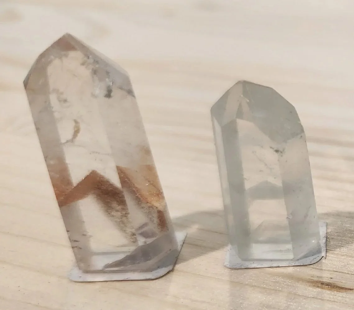 Clear phantom quartz point showing layered mineral inclusions forming ghost-like shapes inside the crystal.