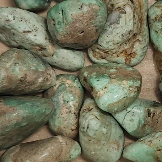 Soft green Variscite stone in polished and rough form with smooth apple-green colouring.