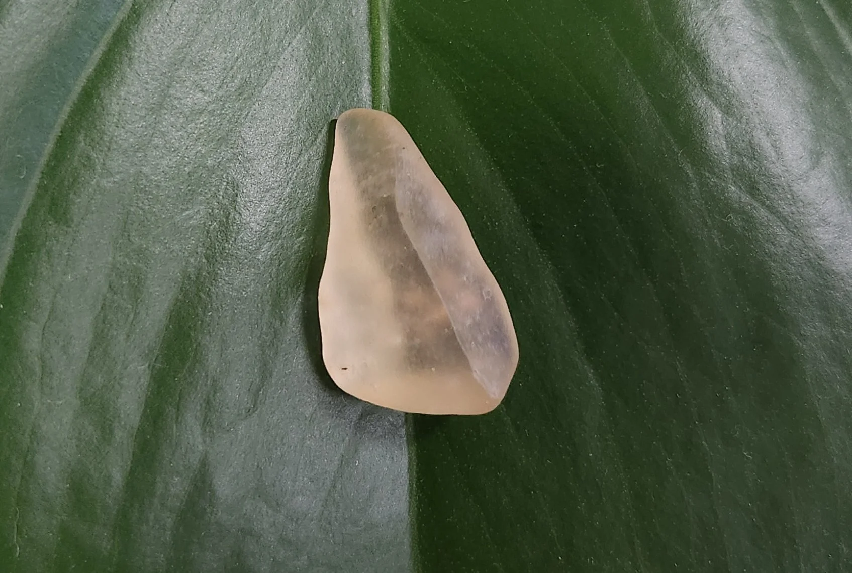 Translucent golden Libyan Desert Glass stone with natural texture and polished edges from the Sahara region.