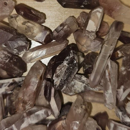 Clear quartz crystal containing soft pink lithium inclusions forming wispy patterns within the stone.