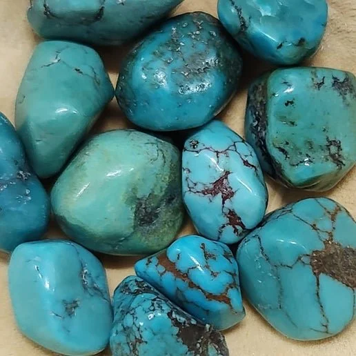 Natural turquoise stone with vibrant blue colour and dark matrix patterns.