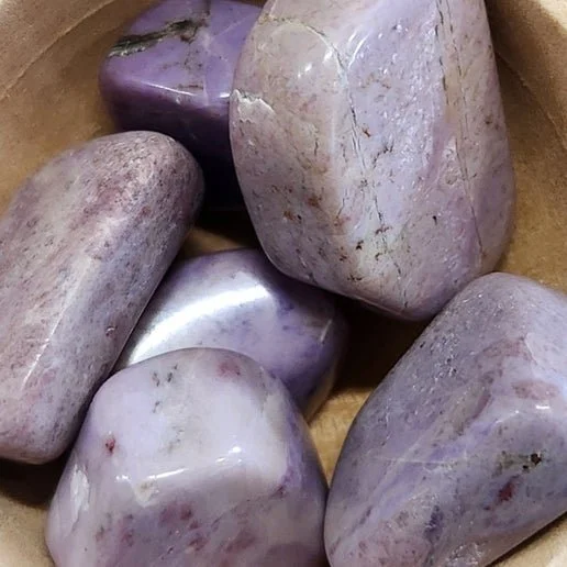 Soft lavender-purple Jade stone displayed in polished and natural forms with smooth calming texture.