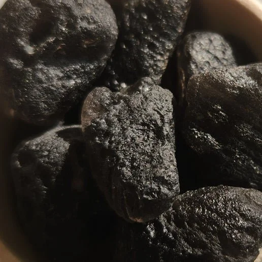 Agni Manitite Pearls of Divine Fire showing natural tektite texture and dark glossy surface