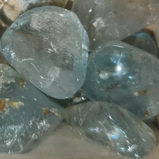 A transparent Blue Topaz crystal with light blue colouring and a faceted, reflective surface