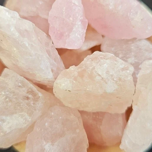 Pale pink Morganite crystal in raw and polished forms displayed on a neutral background.