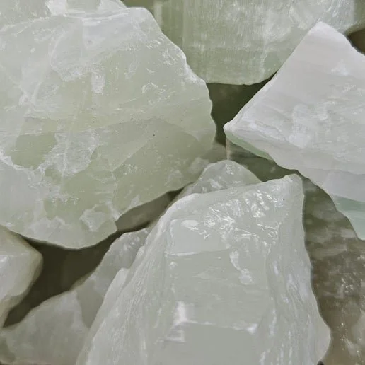 A soft green Pistachio Calcite crystal with gentle translucency and a smooth polished surface.