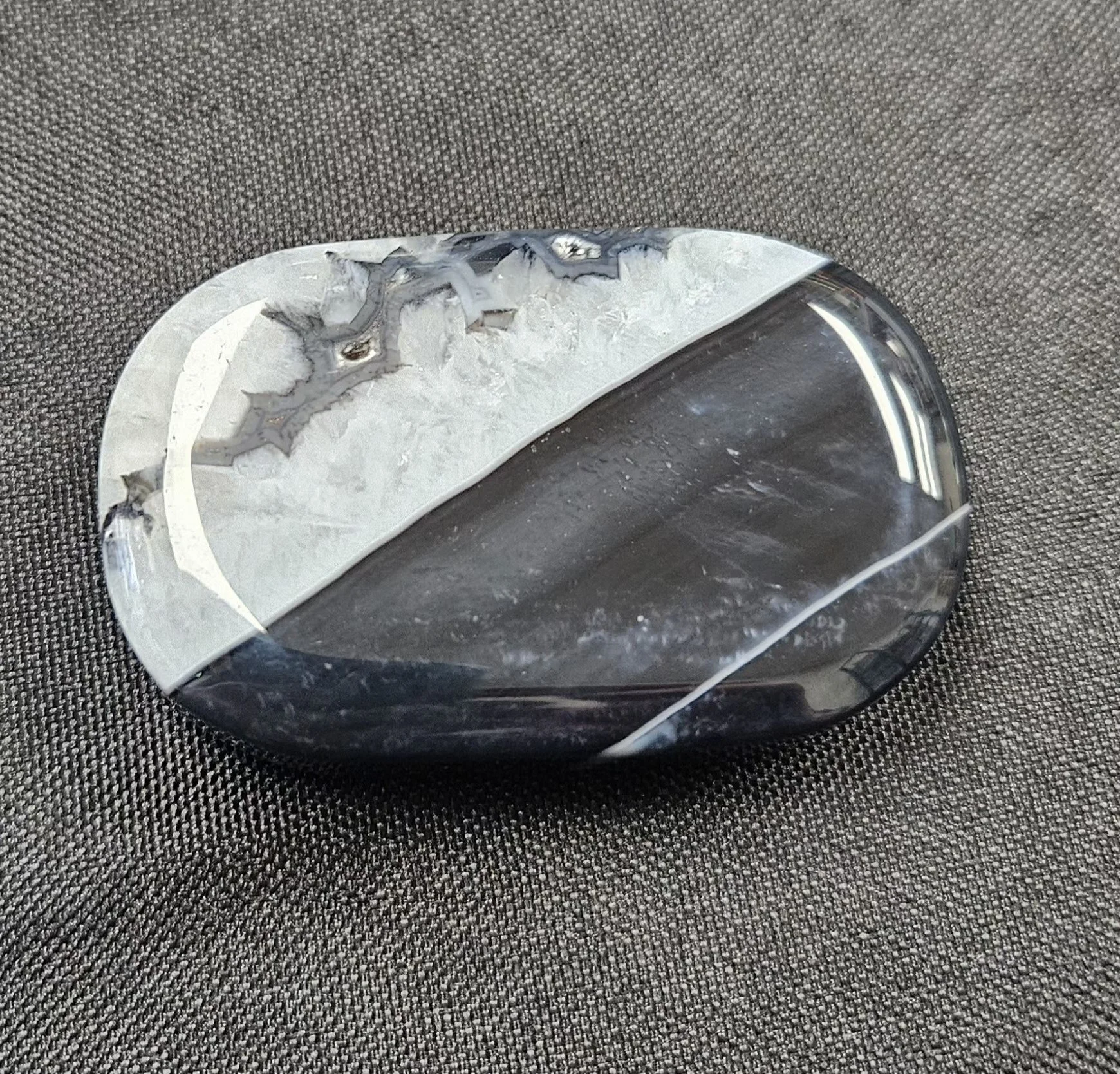 A polished Black Agate stone with a smooth, glossy surface and deep black colouring.