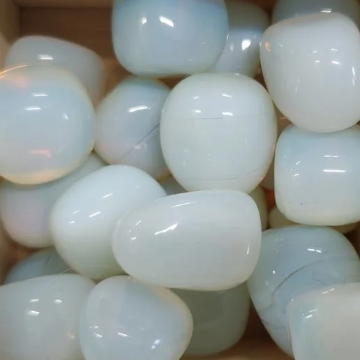 Milky translucent Opalite stone with soft blue iridescent glow shown in polished and tumbled forms.