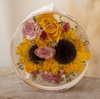Funeral flowers preserved in resin in a circle design
