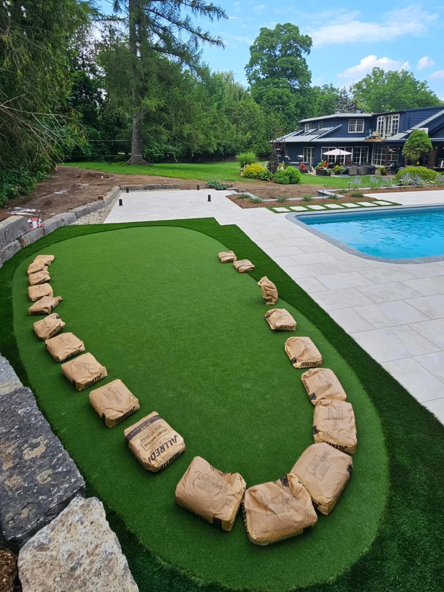 Porcelain Pimp Pad Installation Part 3!

➡️ Rymar -  Pro putt turf with Durablade 95 as the fringe. Best quality material for endless hours of entertainment
➡️ Perennials installed within raised garden bed sections, as well as 10ft tall blue spruces,