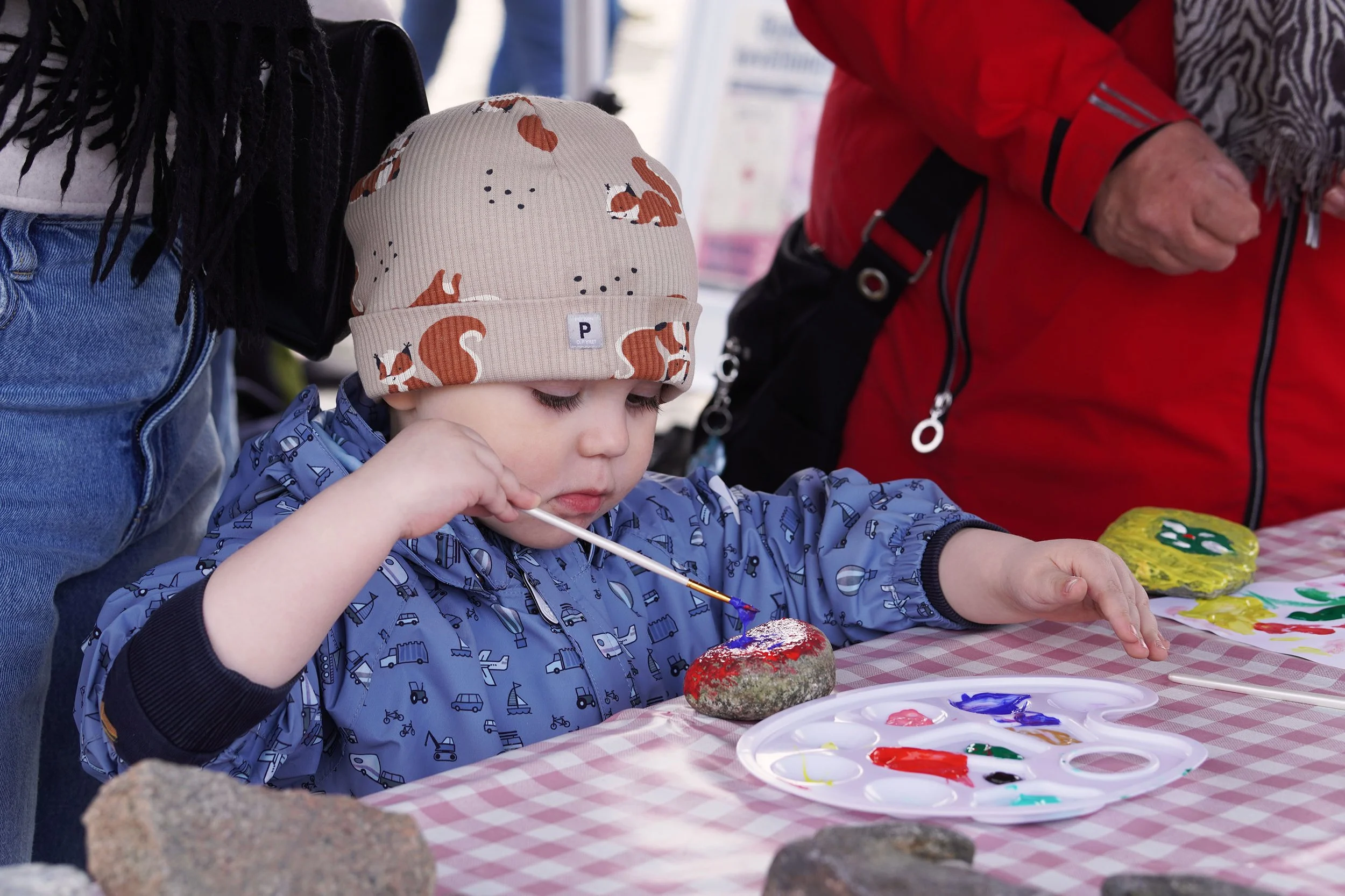 A young visitor painting stones during one of the creative workshops at the event.