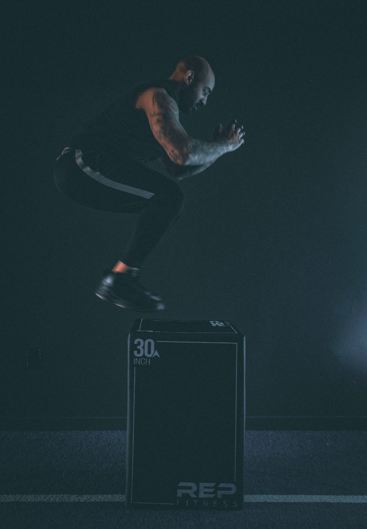 Coach in Oakland CA demonstrating box jumps during group strength class
