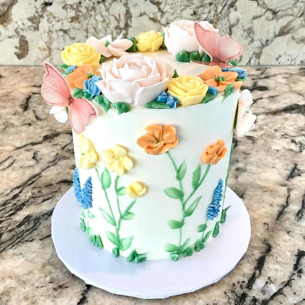 Buttercream cake piped with spring flowers and butterflies