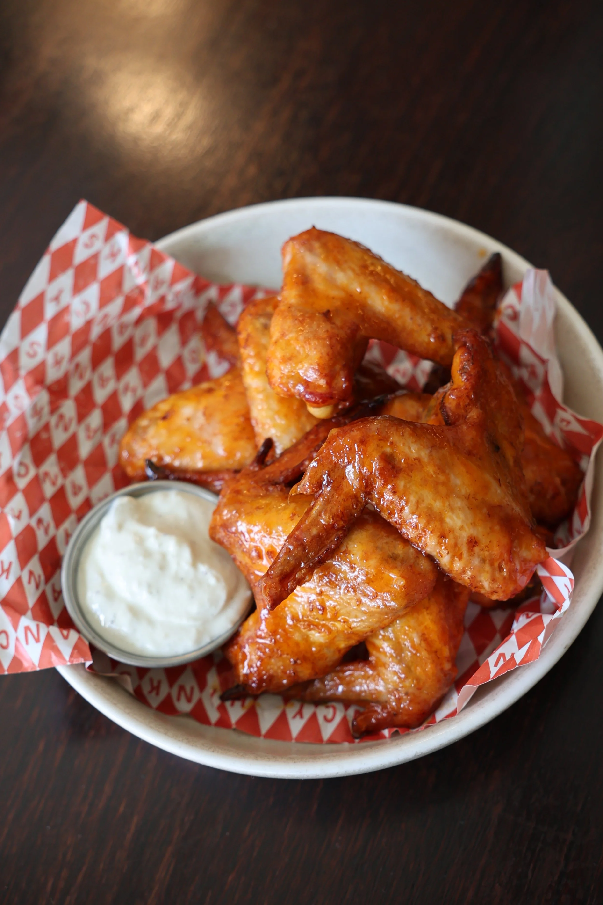 Plate of Fancy Hank's smoked chicken wings with ranch dipping sauce