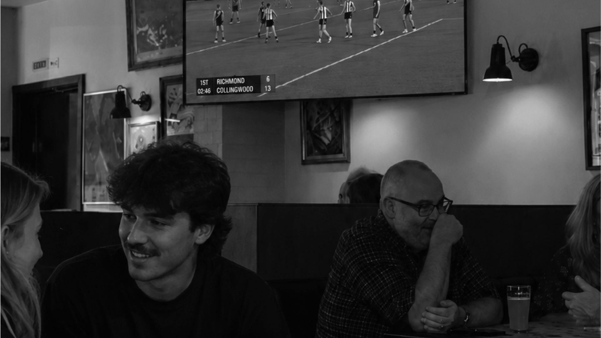 Friends watching the AFL Grand Final on the big screen at Springrock pub with a beer