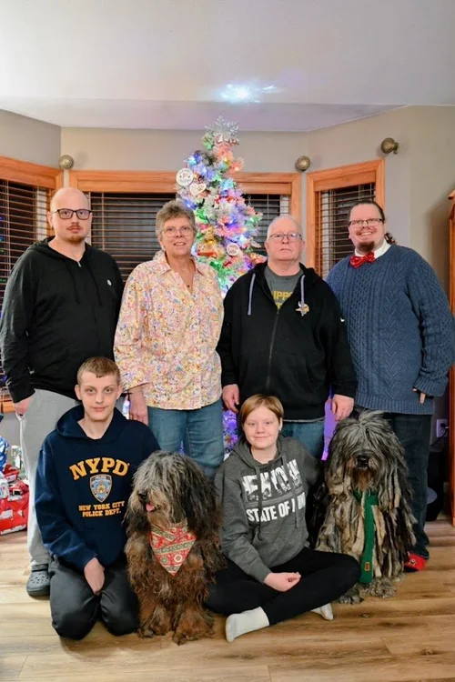 Family sitting with Bergamasco Sheepdogs at Christmas