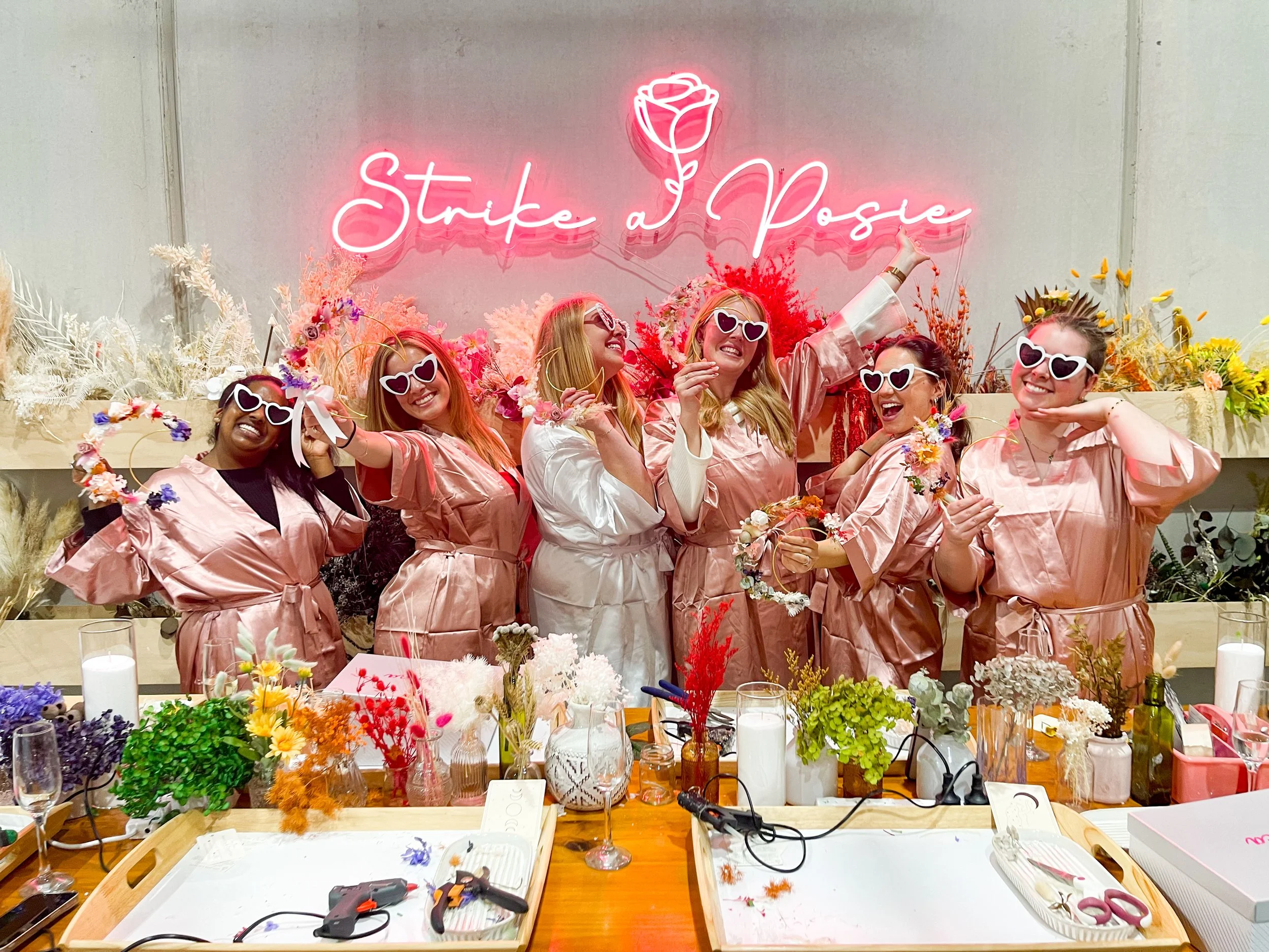 A bride and bridesmaids holding their floral moons they have made at a workshop