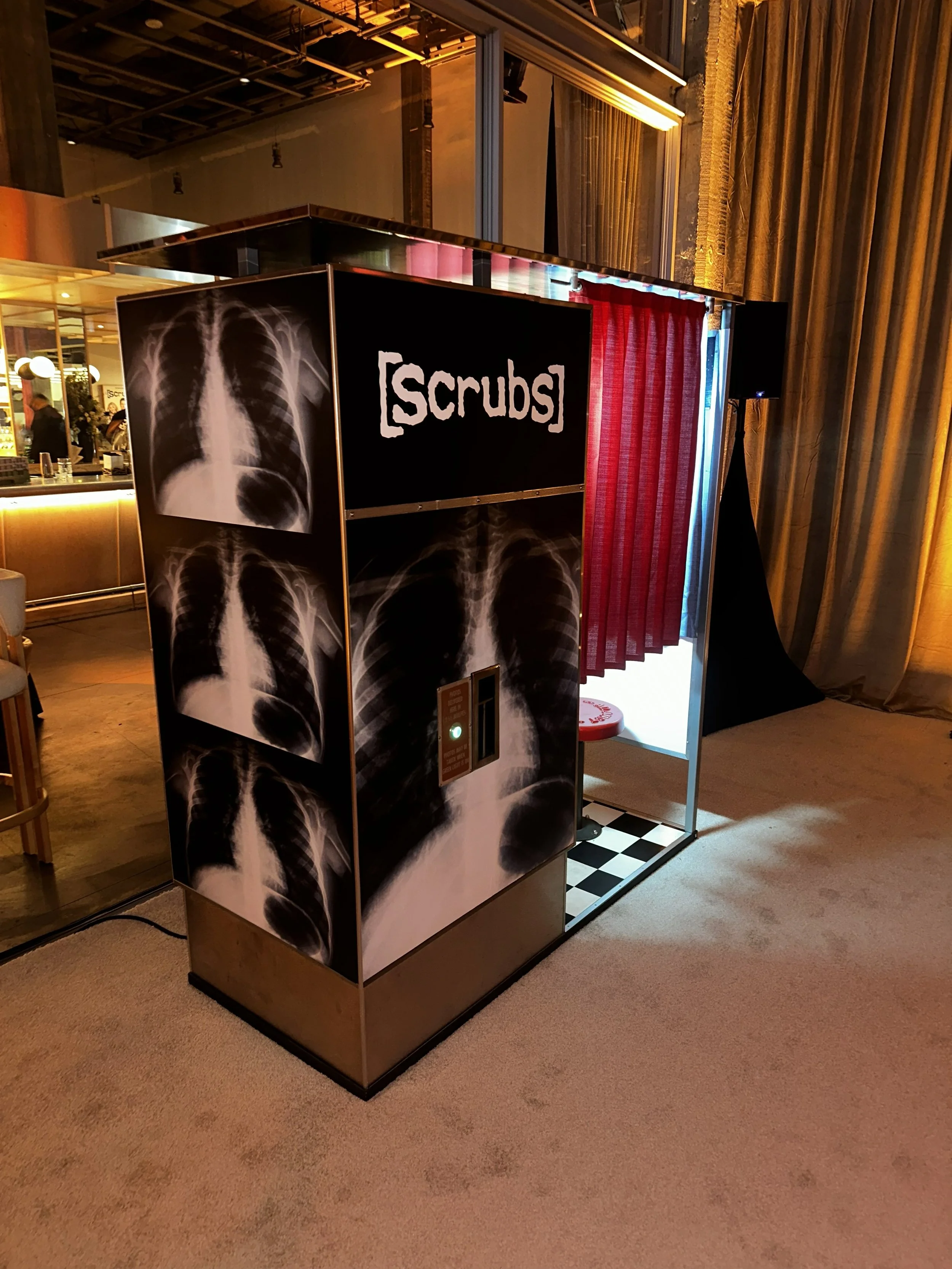 A vintage analog photo booth with a Scrubs tv show decal on it. Model 14