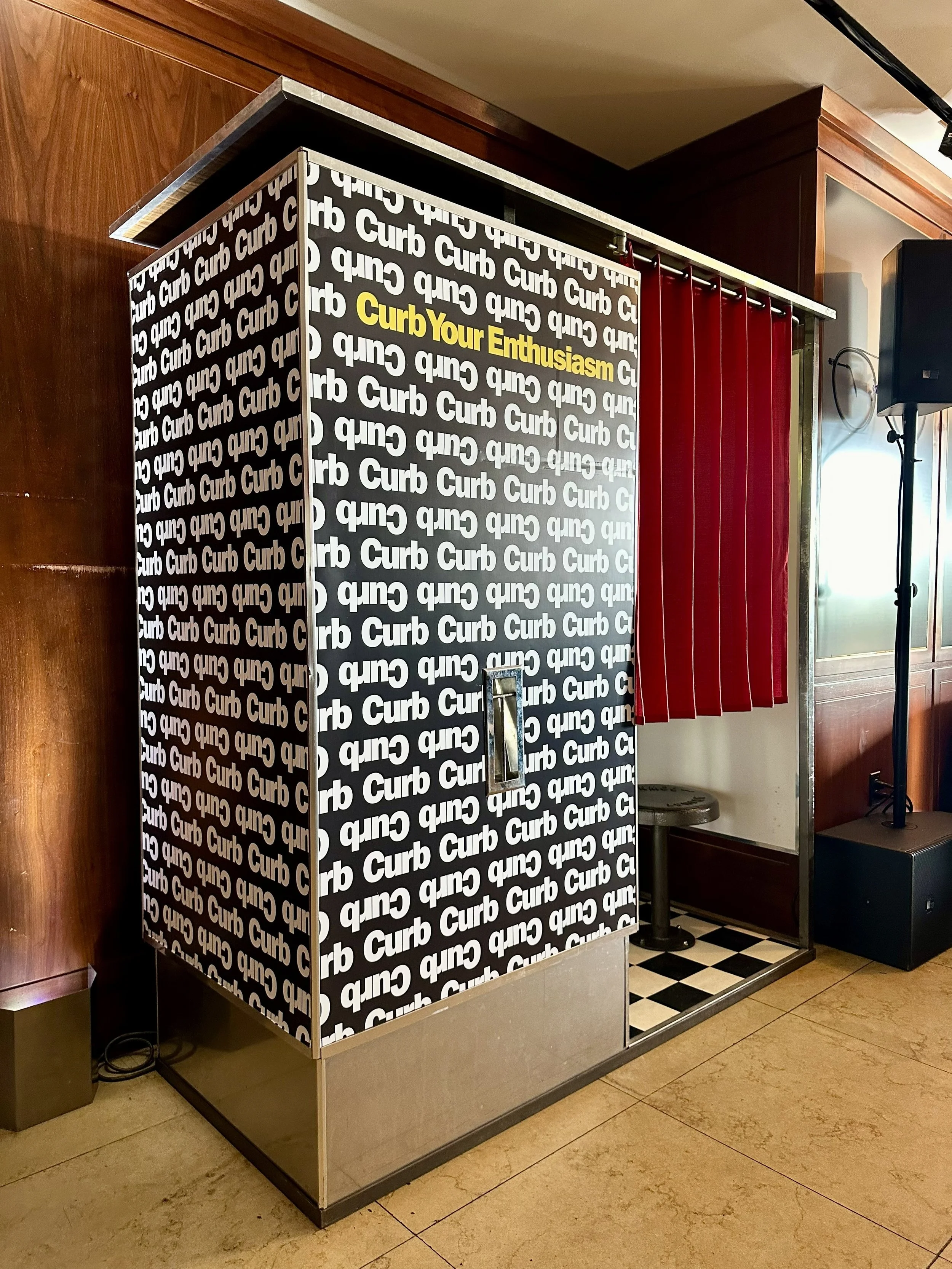 A vintage analog photo booth with a HBO's Curb Your Enthusiasm decal.
