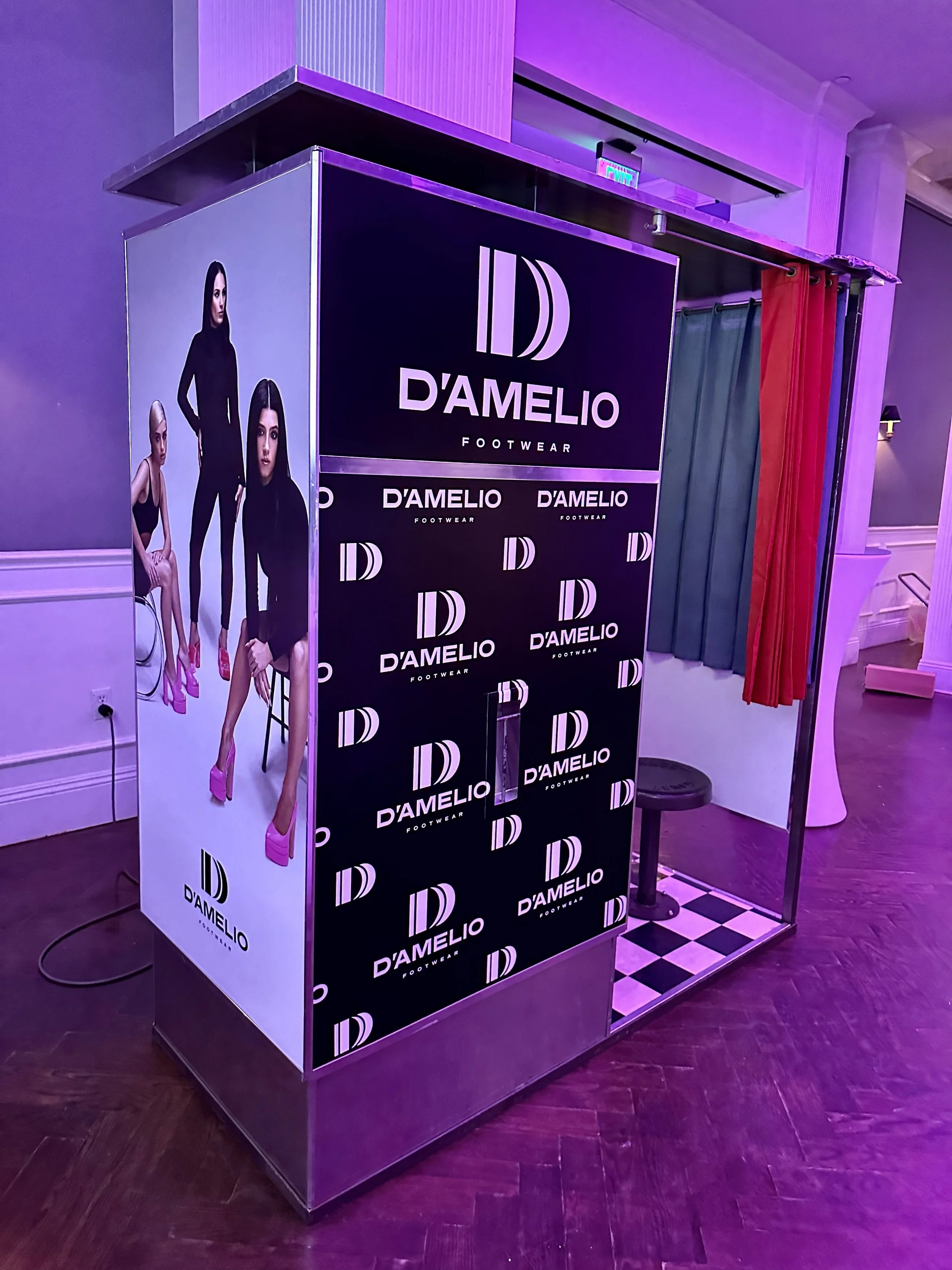 A vintage analog photobooth with a D'AMELIO Footwear decal.