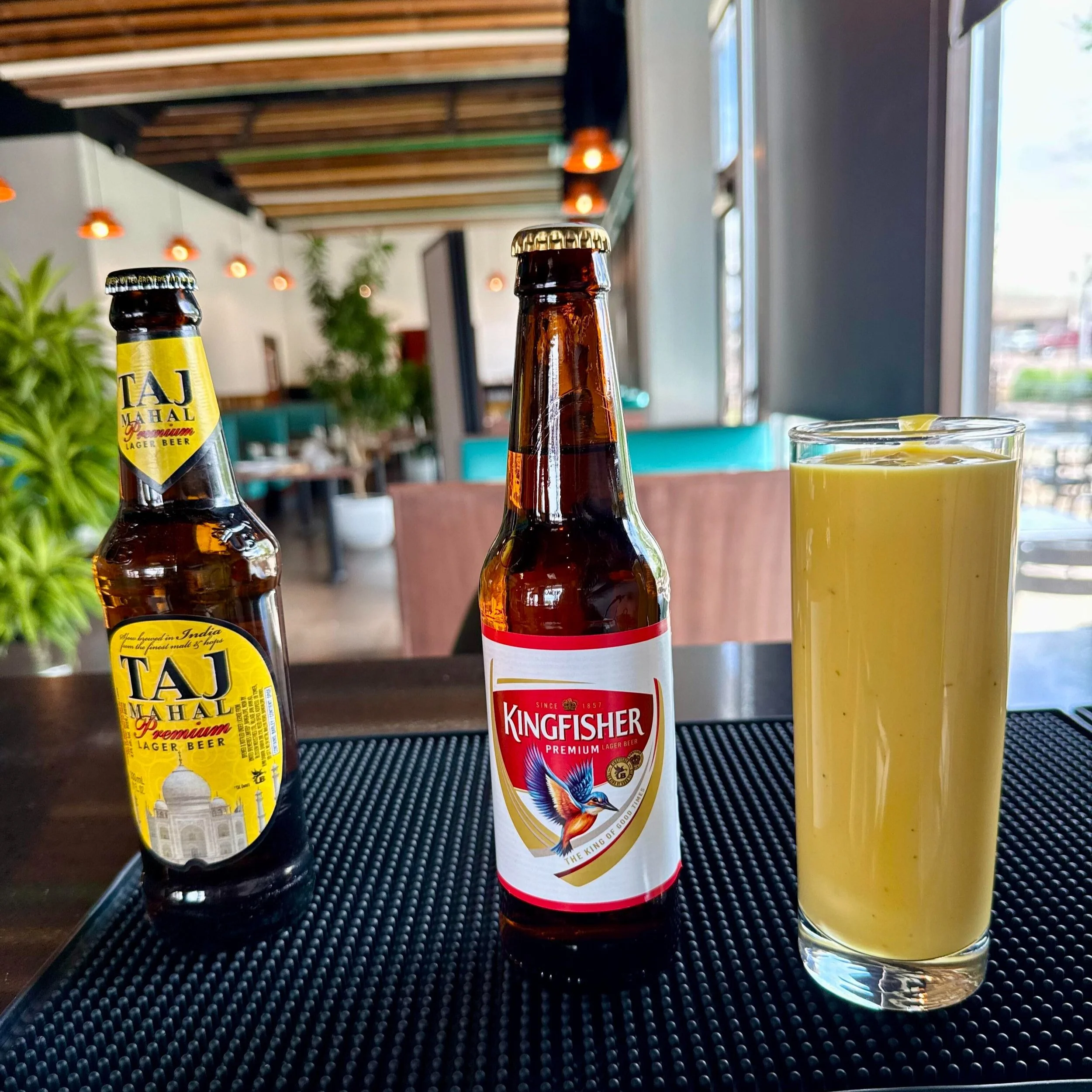 Taj Mahal and Kingfisher Indian Beer next to a glass of Mango Lassi
