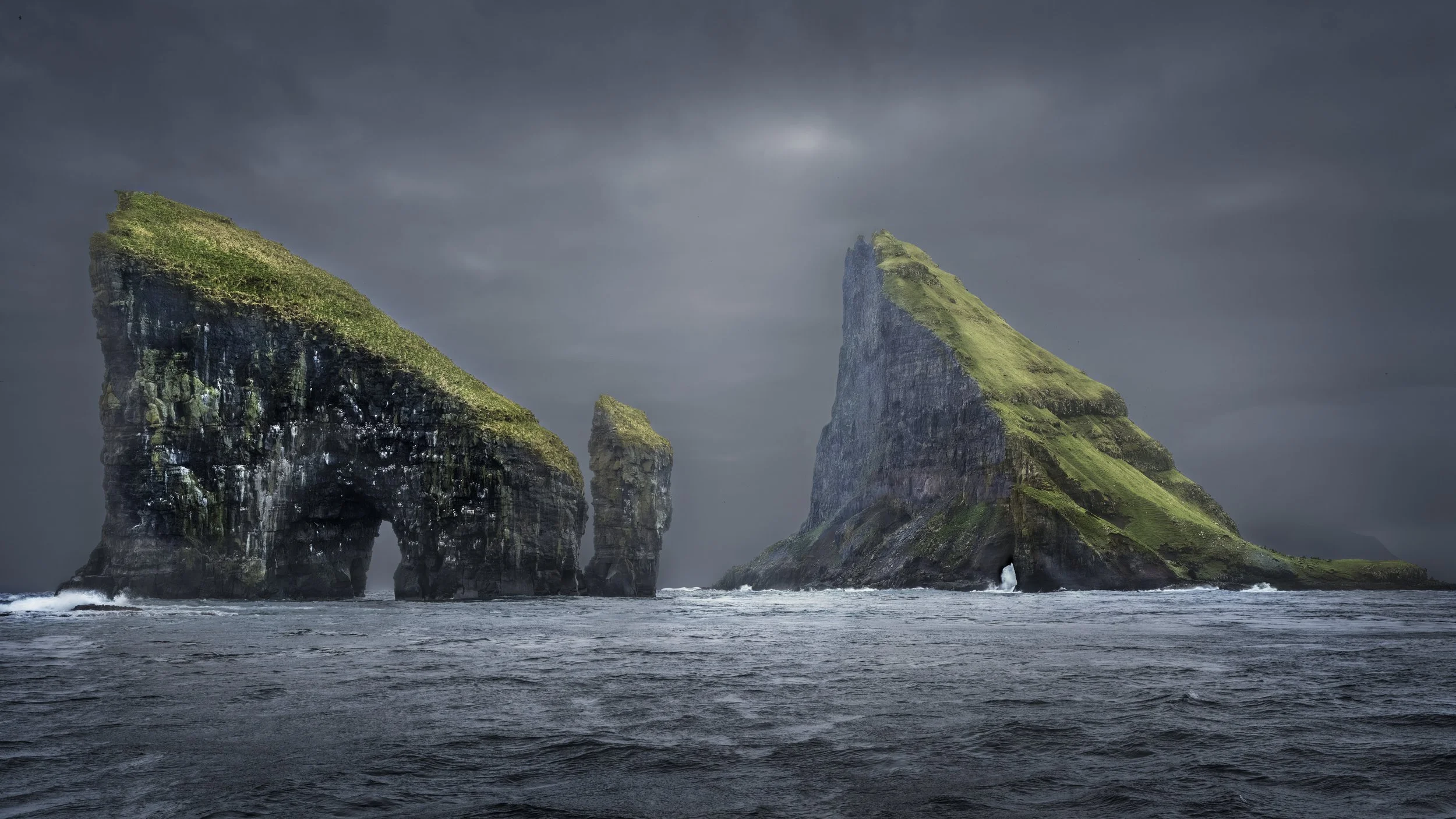 Photograph of landscape in the Faroe Islands, focusing on atmosphere and terrain.