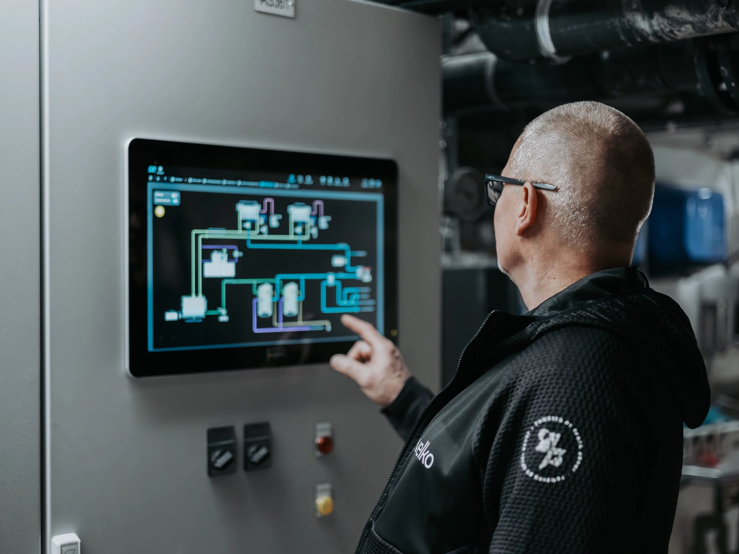 Person som tittar på en datorskärm med ett tekniskt schema eller diagram i ett industrilaboratorium.