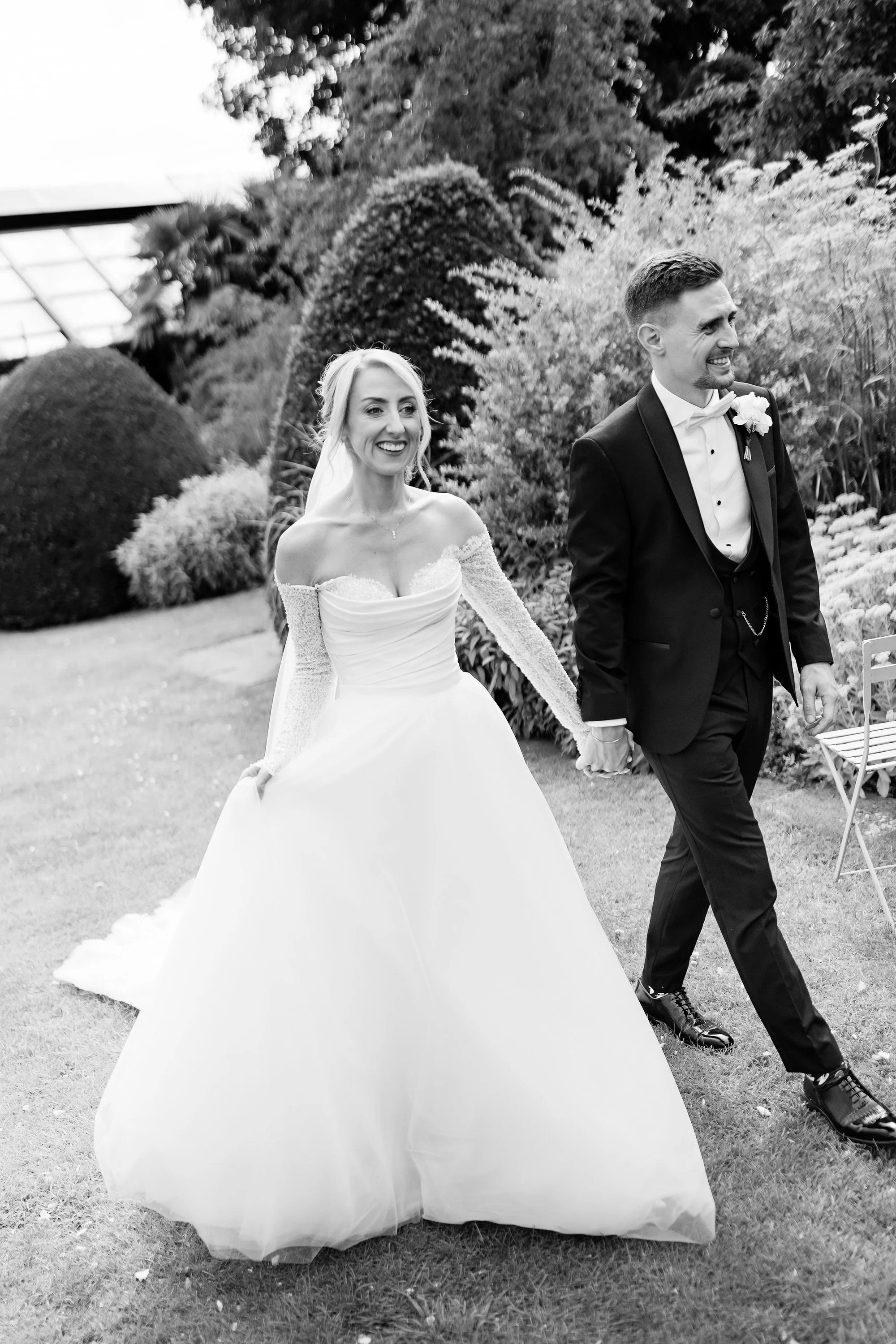 couple walking in black and white at chapel house estate wedding 