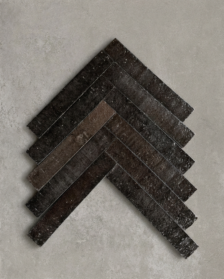 TOSHIE is a hand-finished Japanese ceramic tile with a deep mocha glaze and richly textured surface, bringing depth, drama, and tactile character to walls and floors.
