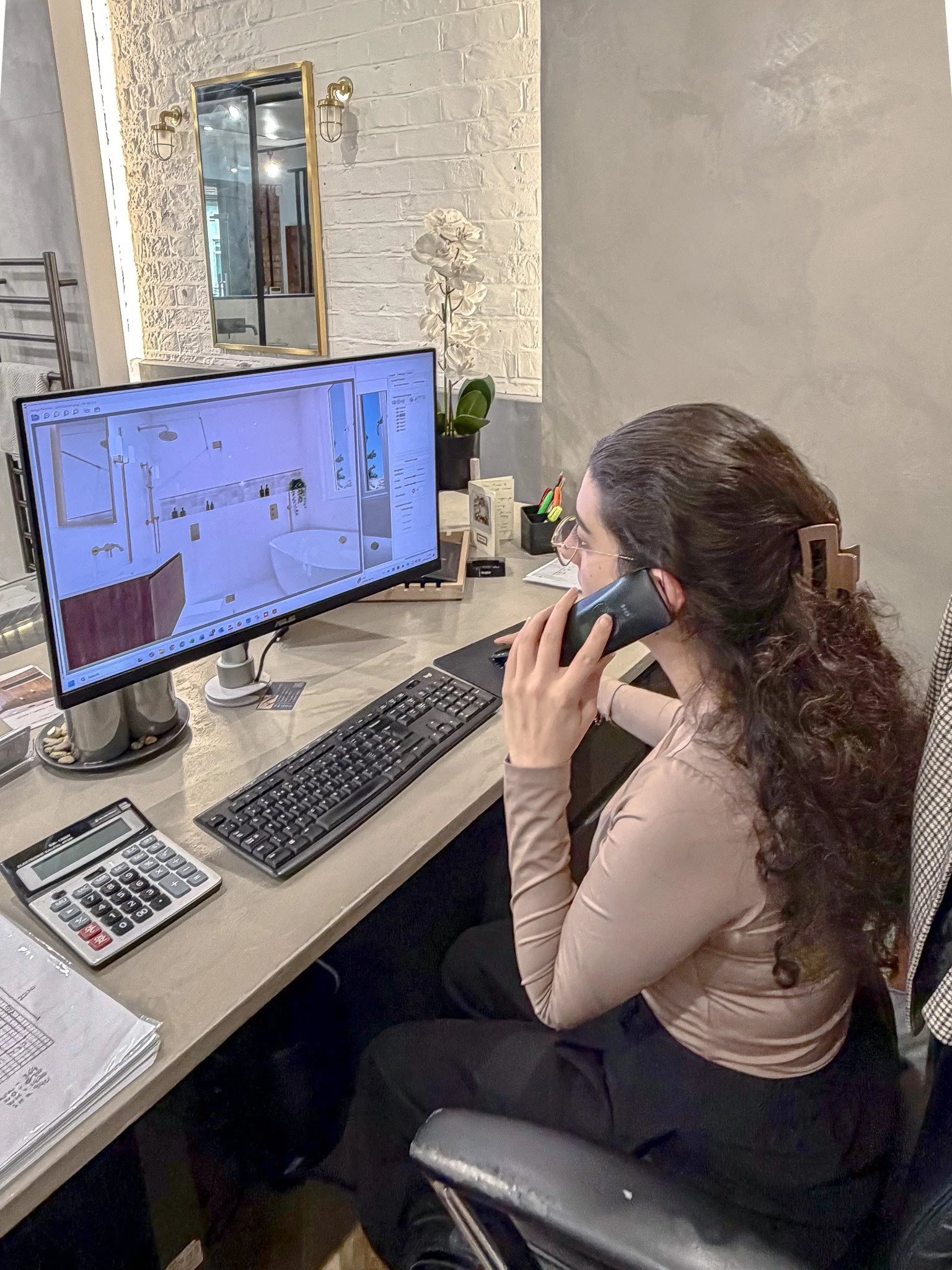 North London bathroom designer reviewing 3D bathroom render during a client consultation call at the Muswell Hill showroom.