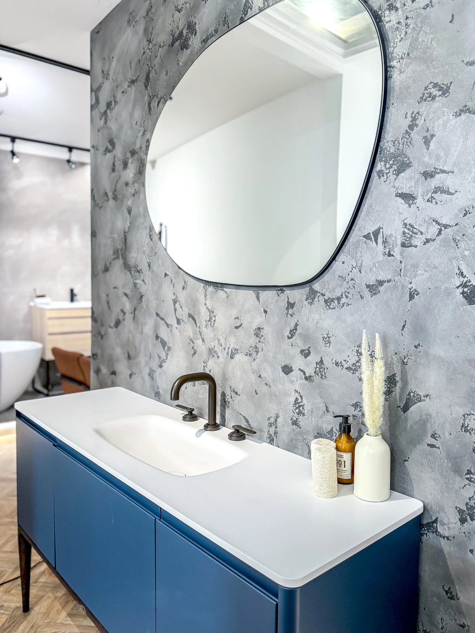 Microcement bathroom wall with organic mirror, modern basin and bronze tapware in North London