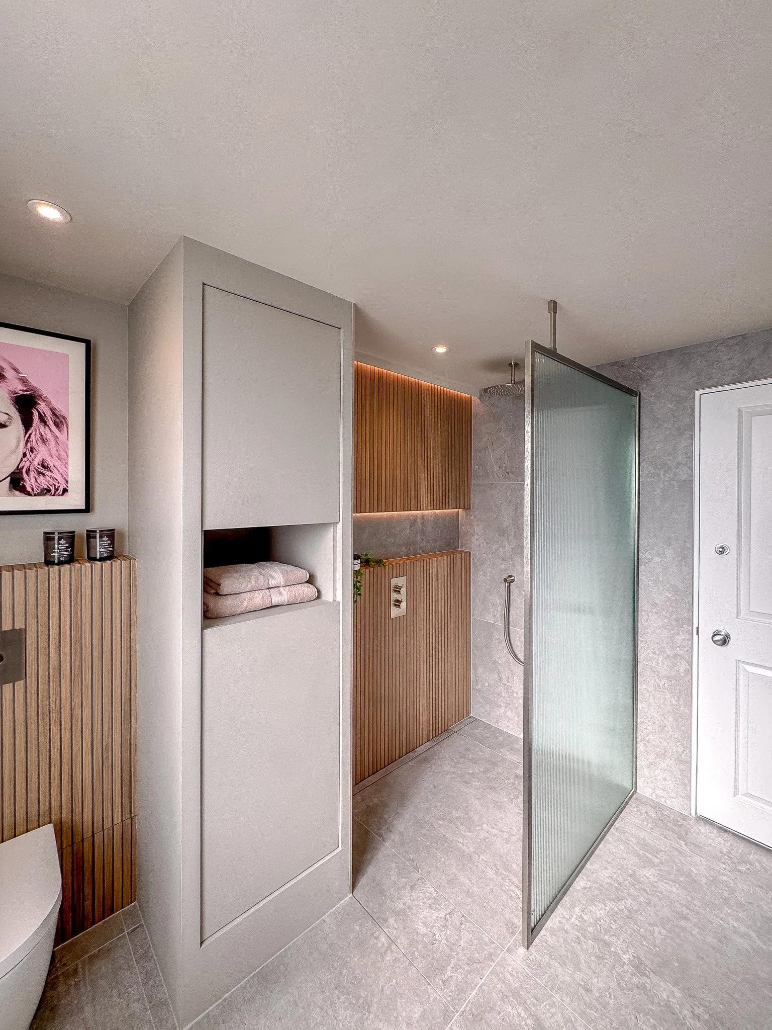 Contemporary bathroom with fluted wood cabinetry, walk-in shower and frosted glass screen in North London