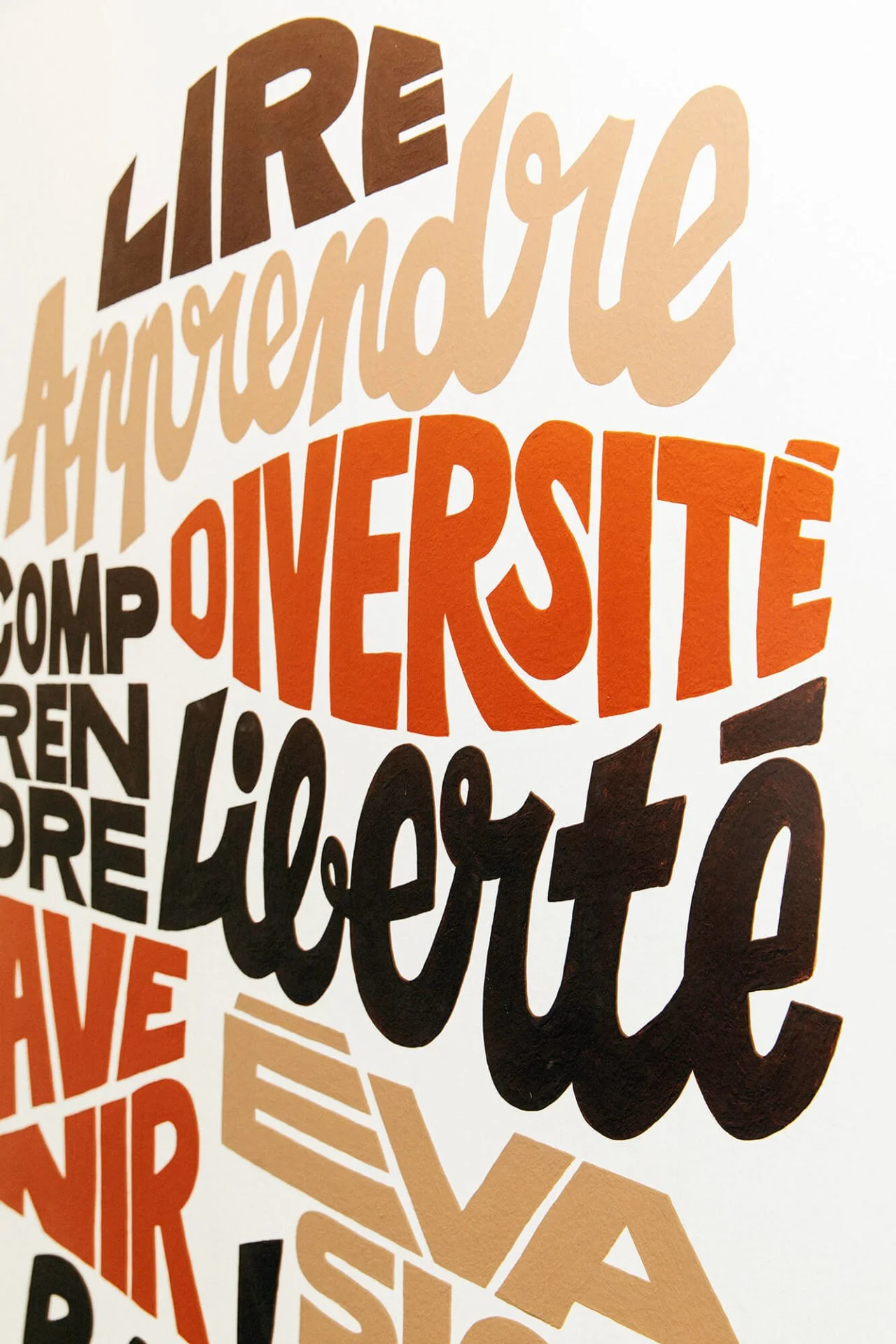 Mots colorés peints sur un mur, dont "LIRE", "Apprendre", "DIVERSITÉ", et "Liberté".