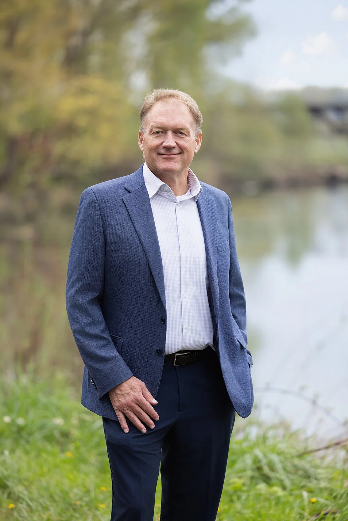 Kirkland Executive Headshots of man in blue suit by river