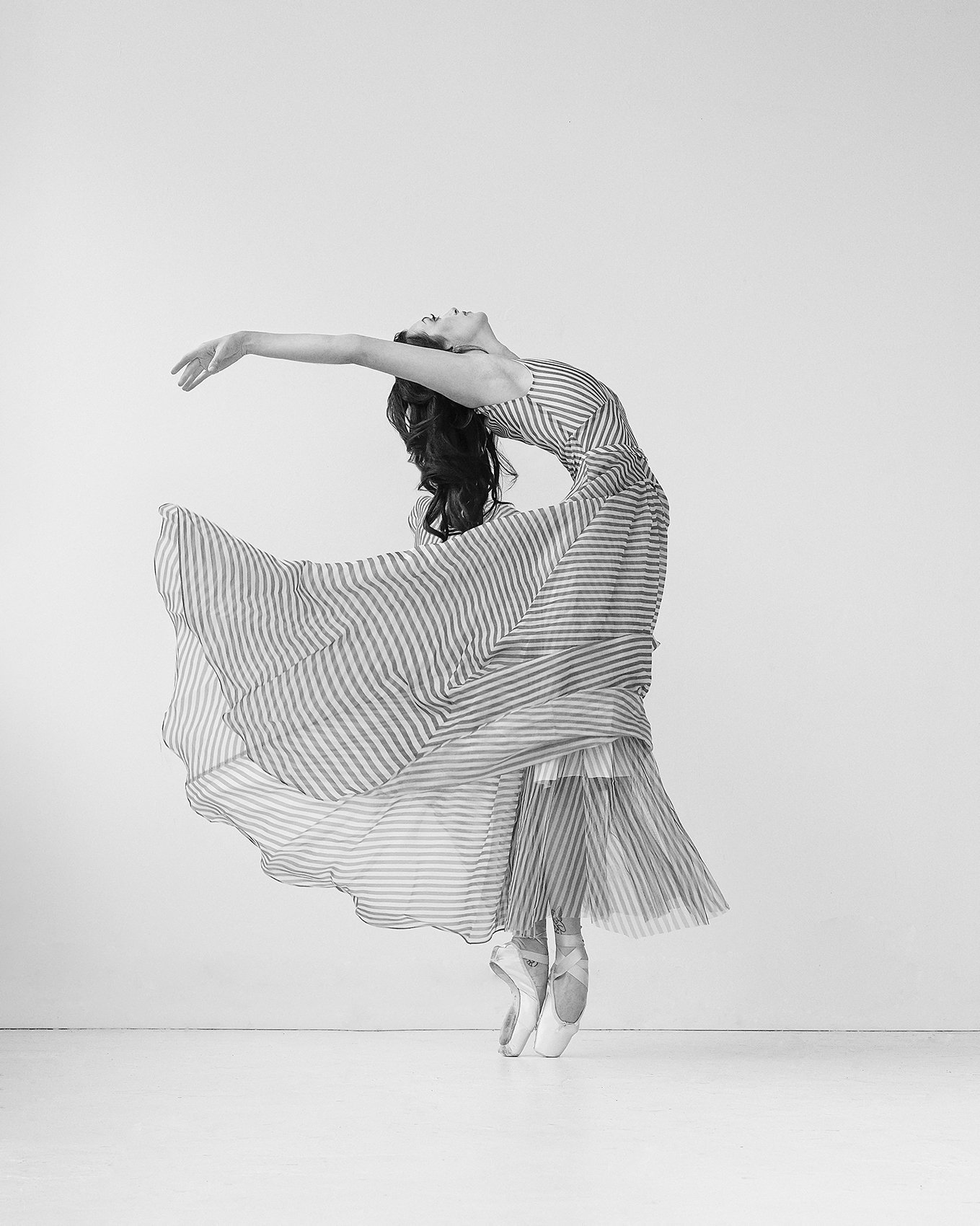 Woman jumping in the air with her arms flailed backwards during Dance Photo Session with Beauclair Photography