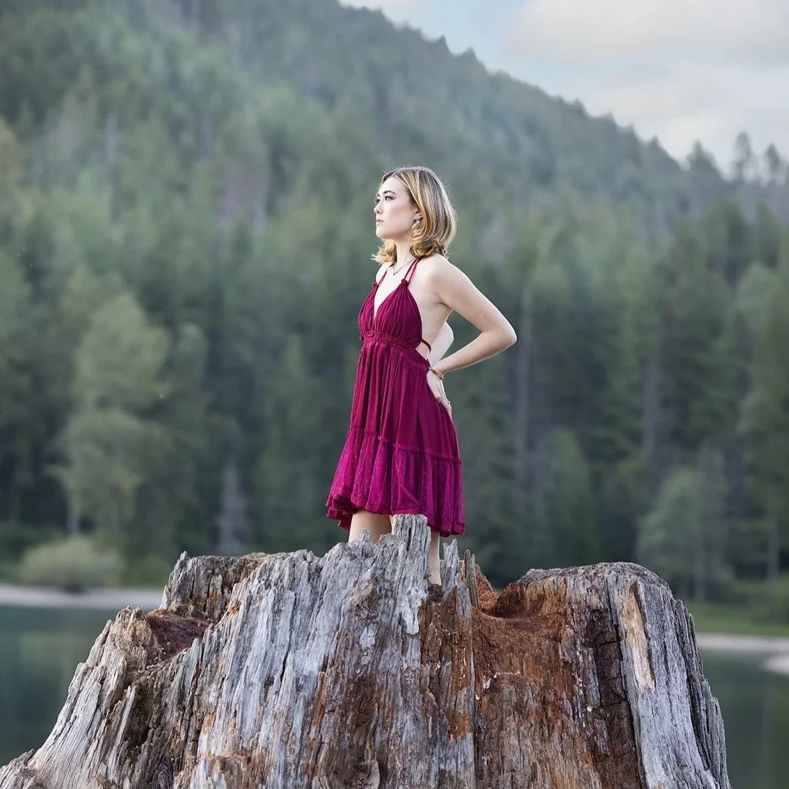 Rattlesnake lake senior portraits of girl in red dress on top of large tree stump with forest in background by senior portrait photographer, Beauclair Photography in Kirkland Washington
