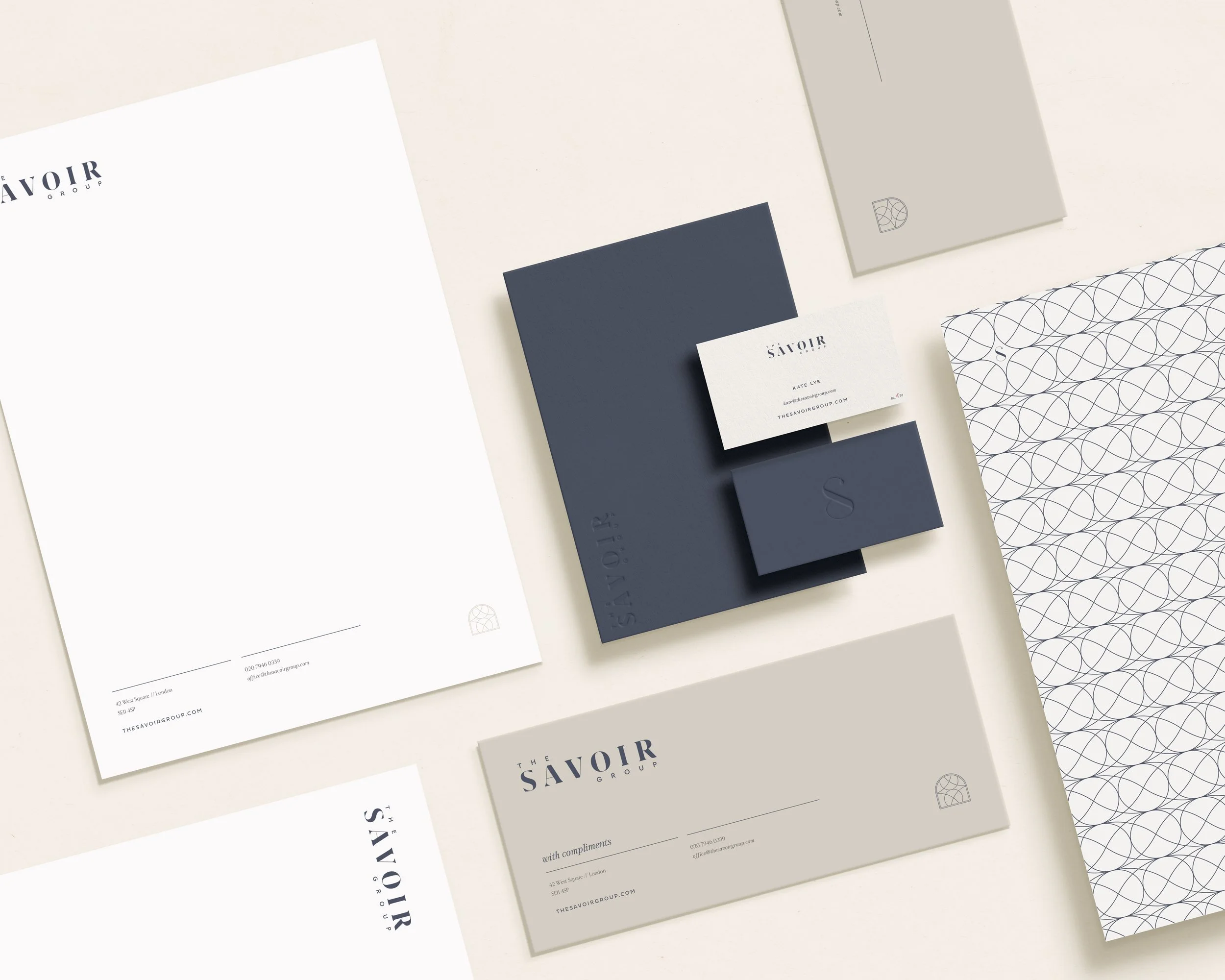 A collection of minimalist business stationery including letterhead, business cards, and envelopes with navy blue, beige, and white colors, featuring geometric line patterns and the logo 'THE SAVOIR GROUP'.