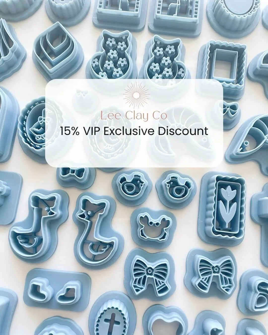 Assorted blue cookie cutters in various shapes including animals, flowers, bows, and geometric designs displayed on a flat surface.