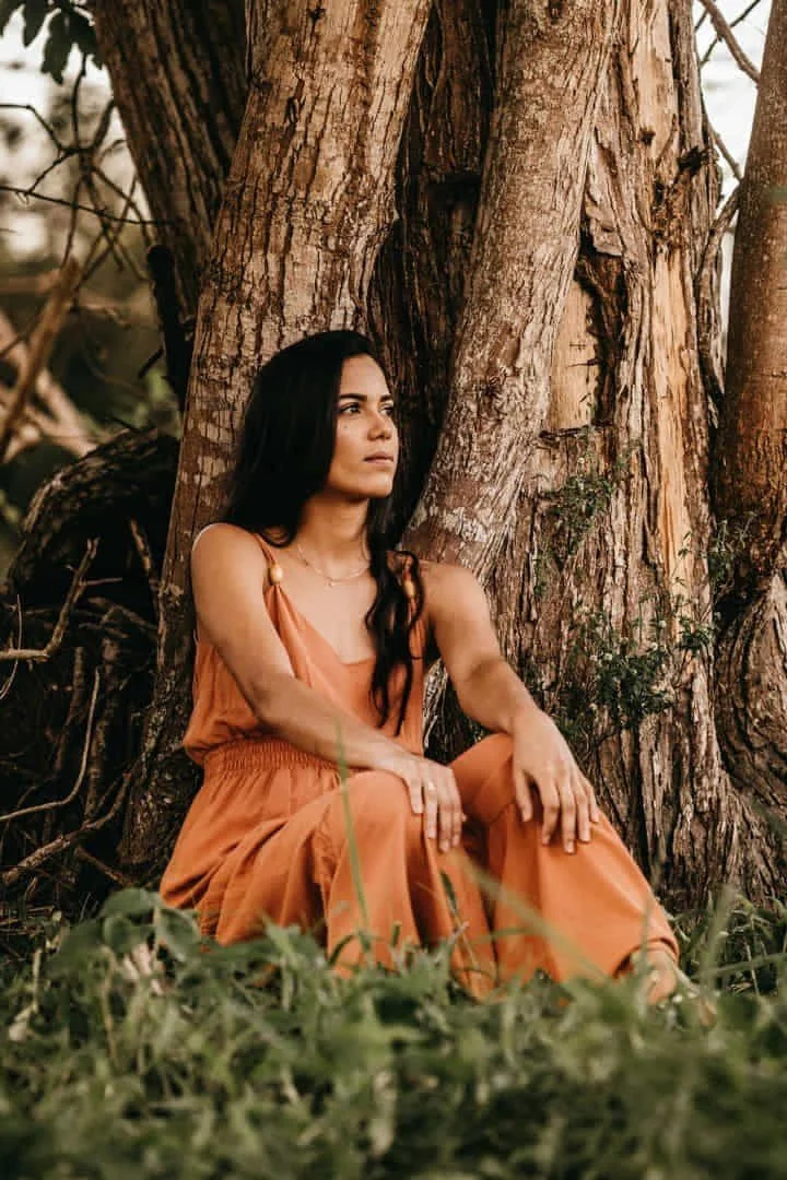 a girl sitting at a tree thinking
