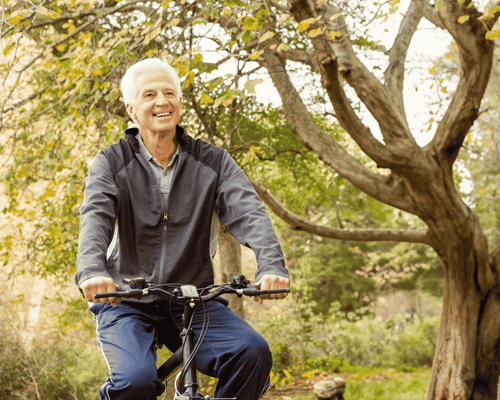 older man riding a bike outside