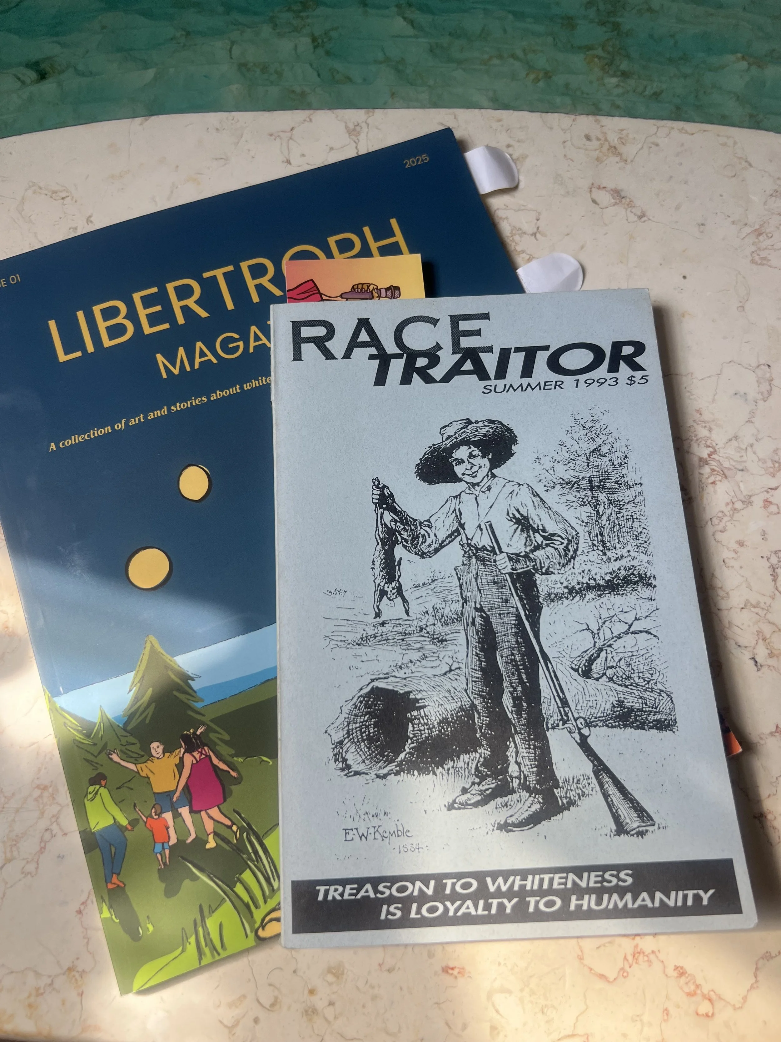 Photo of 1993 issue of Race Traitor atop Libertroph's 2025 Inaugural Issue