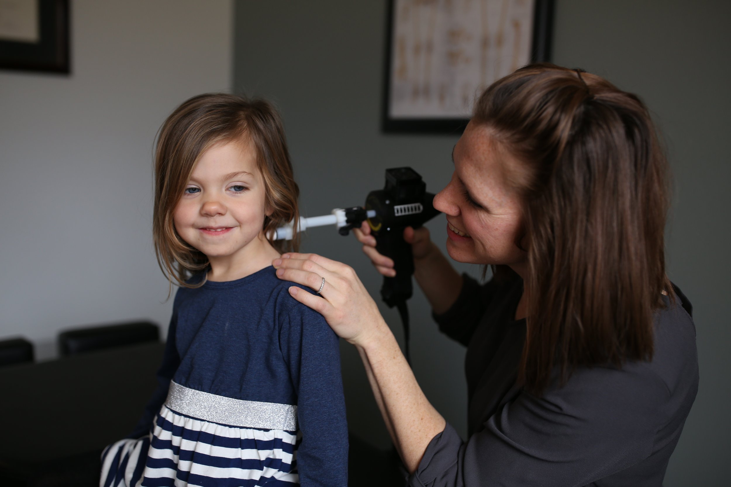 Young child recieving an adjustment using Arthostim from female doctor.