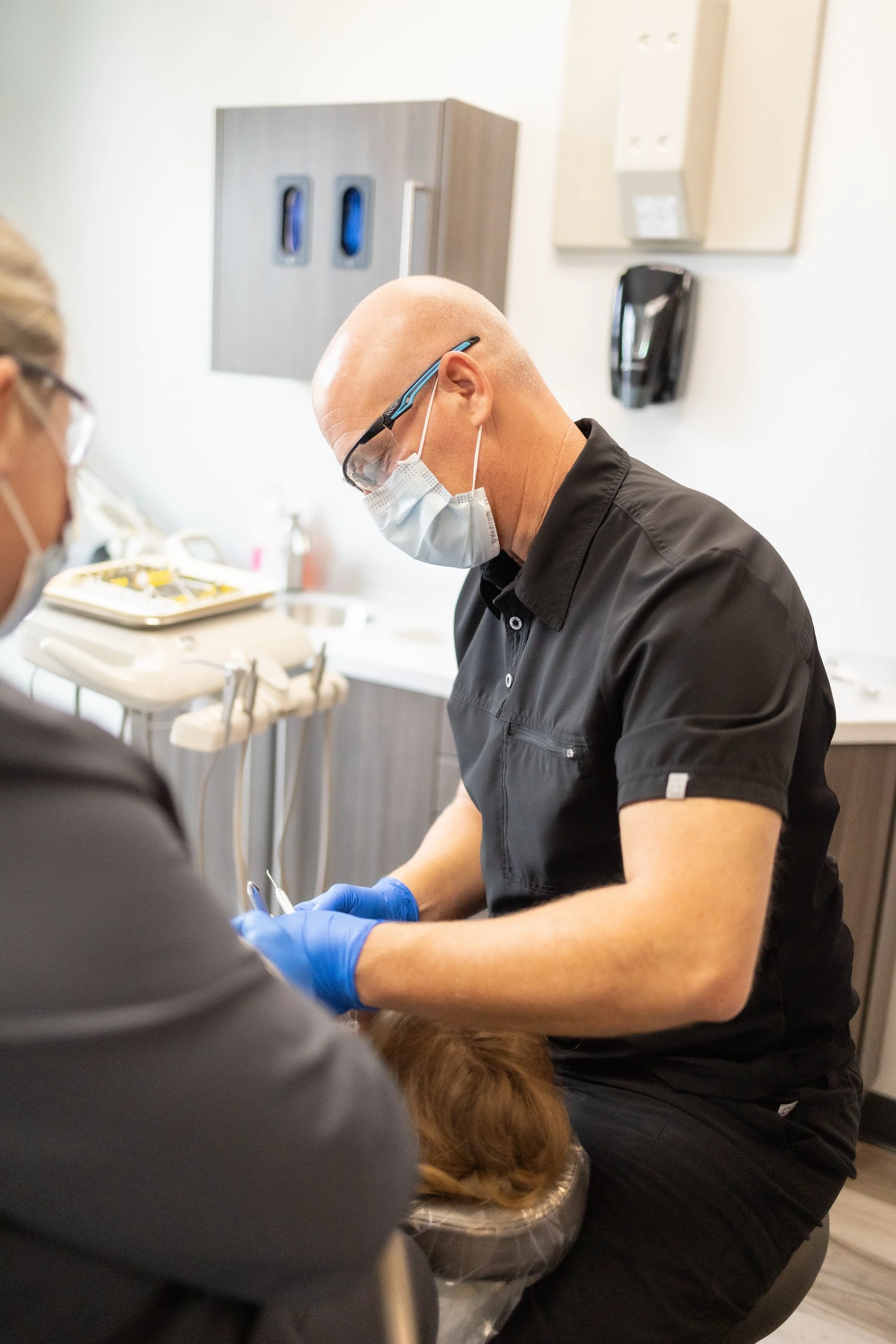 Dentist in mask and gloves treating a patient at Kalina Dental