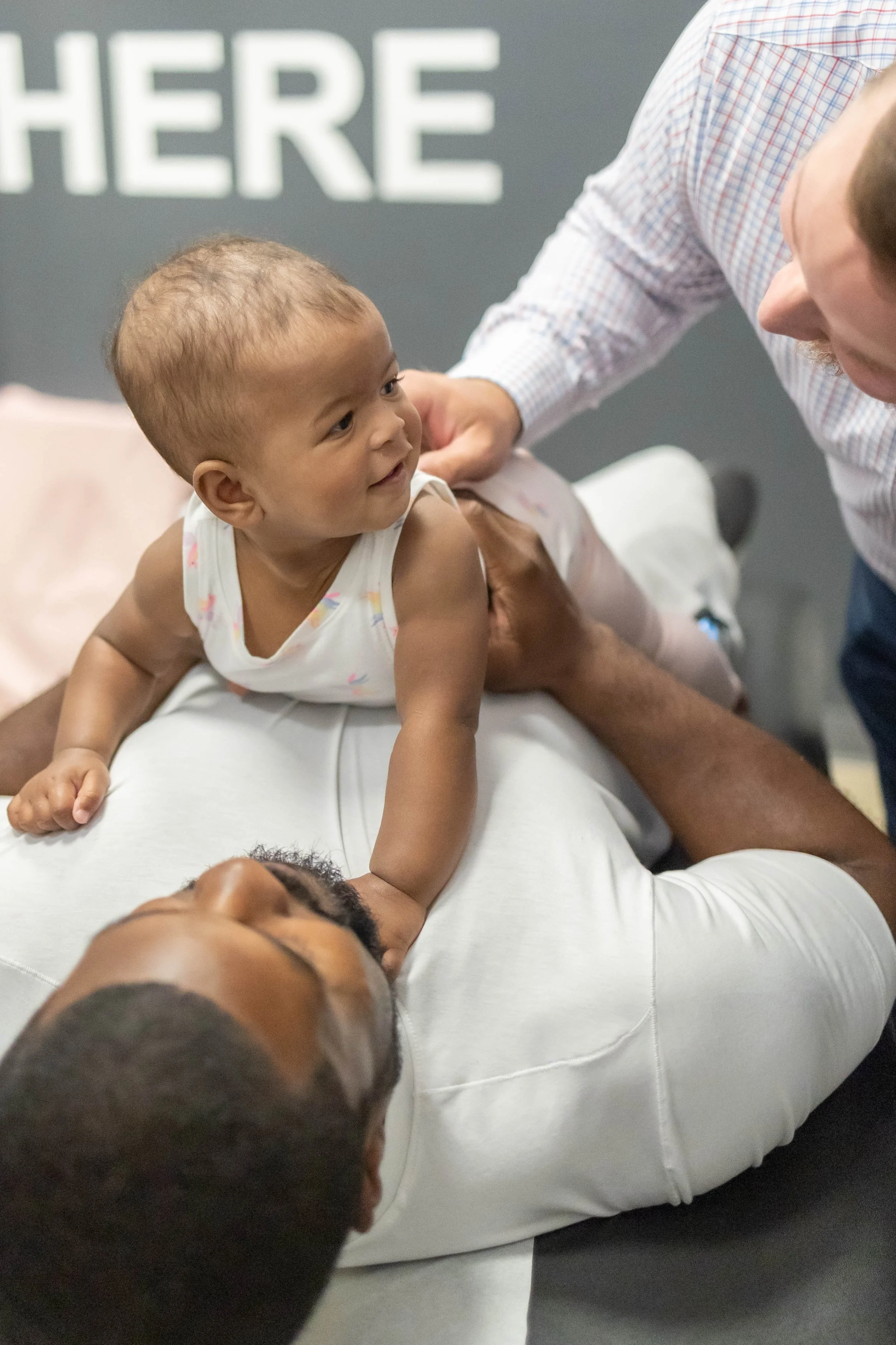 Chiropractor gently adjusting a smiling baby at TOV Chiropractic