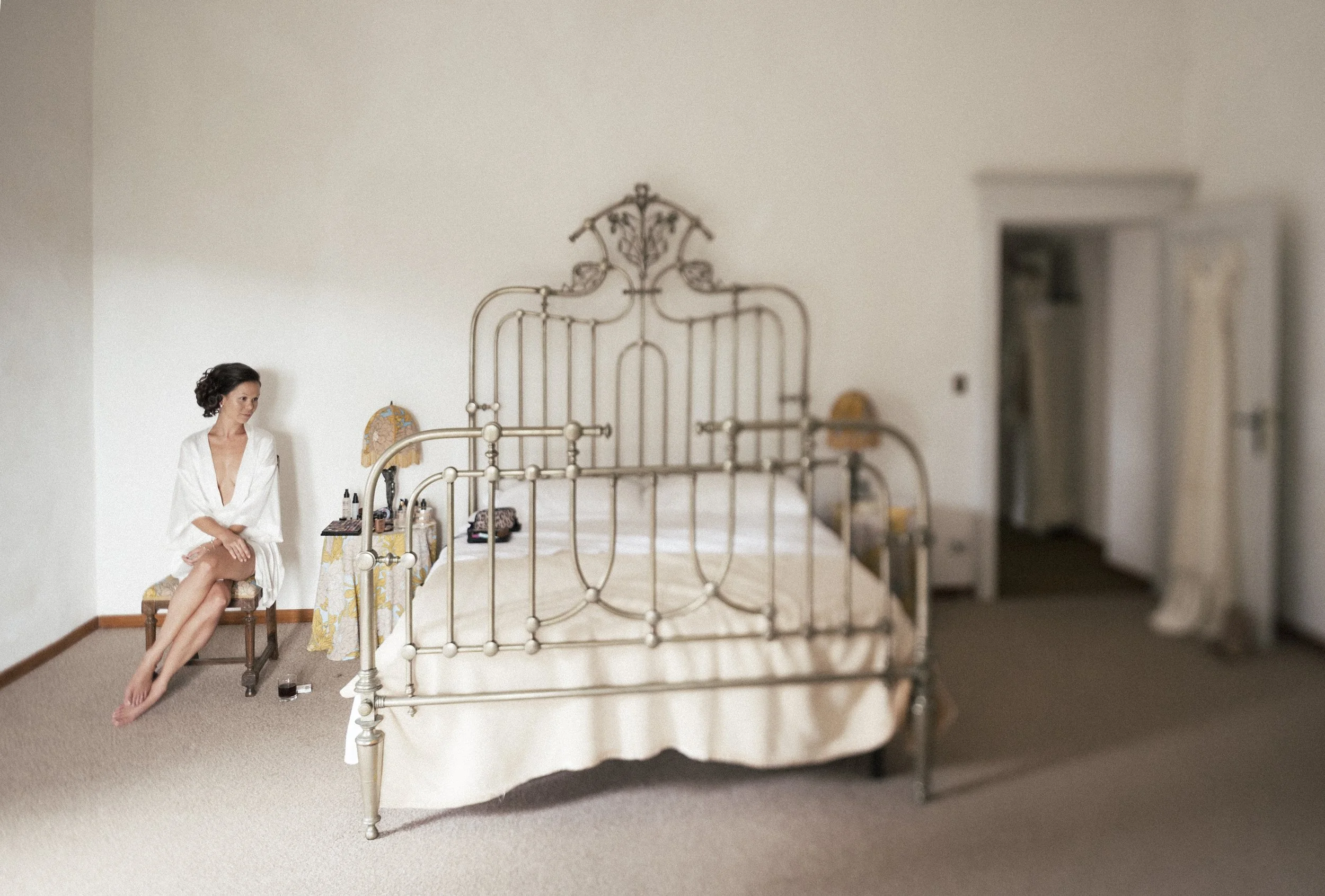 Bride getting ready in a sunlit bedroom of a historic villa during a destination wedding in Florence, Italy.
