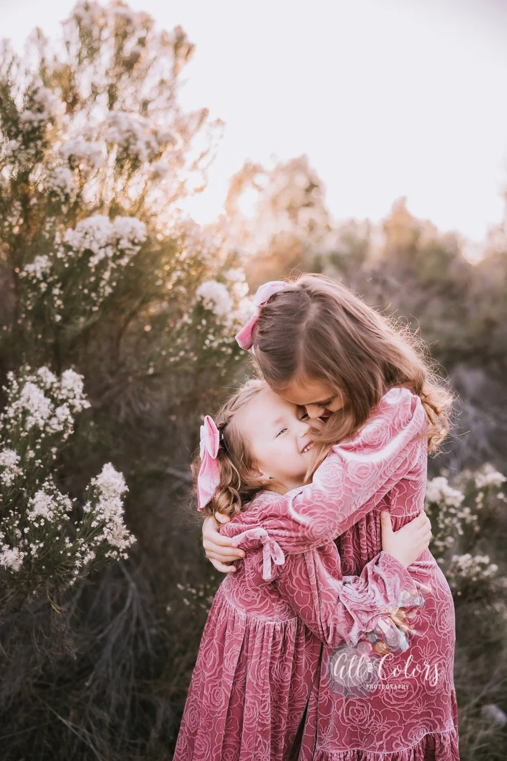 two sisters hugging each other on a field