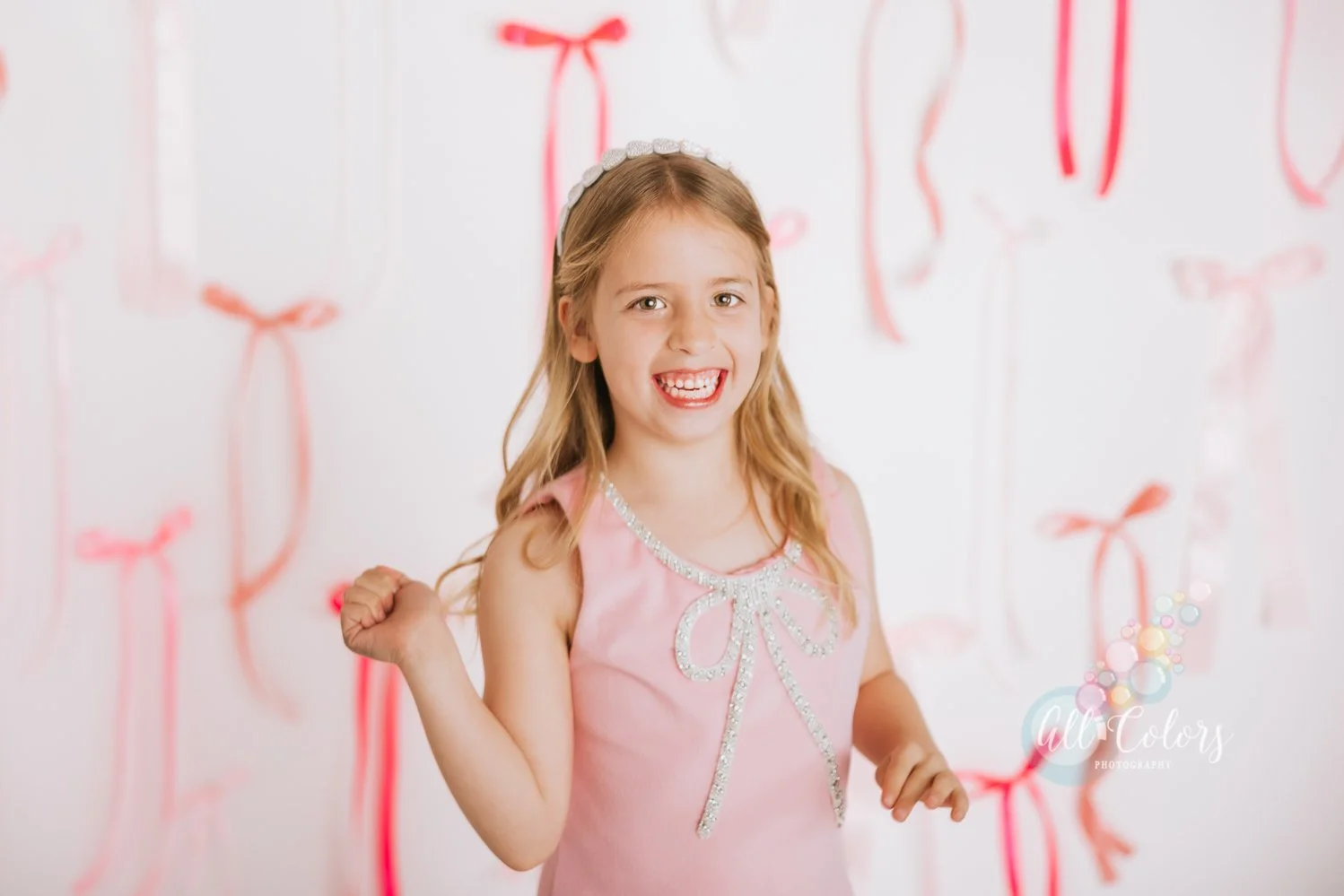 little girl in front of a backdrop made of pink bows