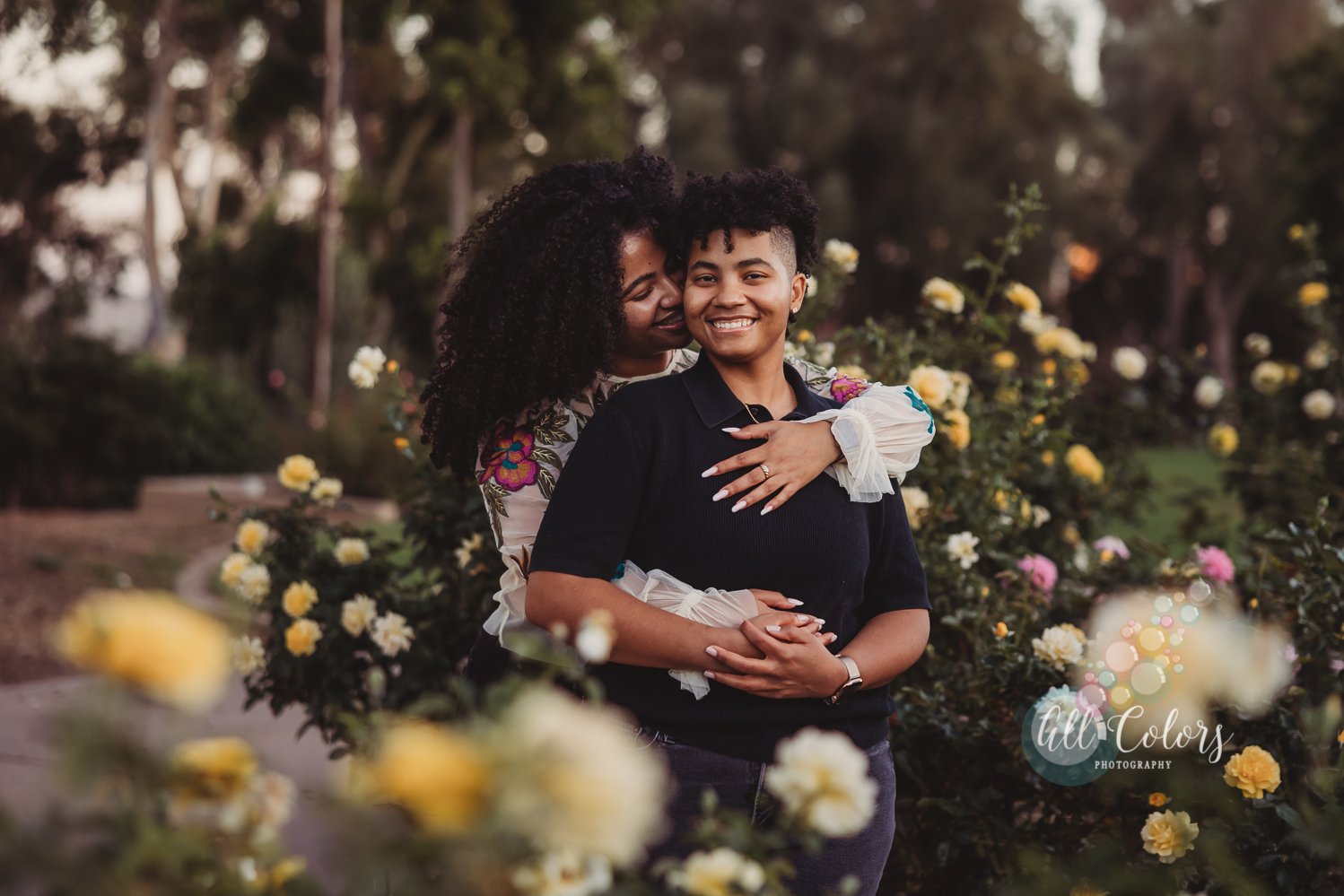 Couple hugging in the middle of yellow roses