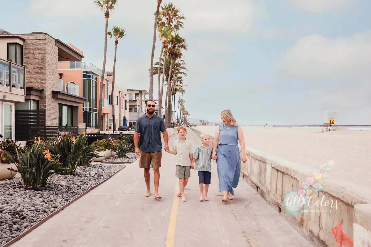 Couple with their two sons walking on the boardwalk in Mission Beach, San Diego.