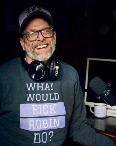 jeremy chapman with glasses and a cap in a recording studio with a podcast microphone and computer